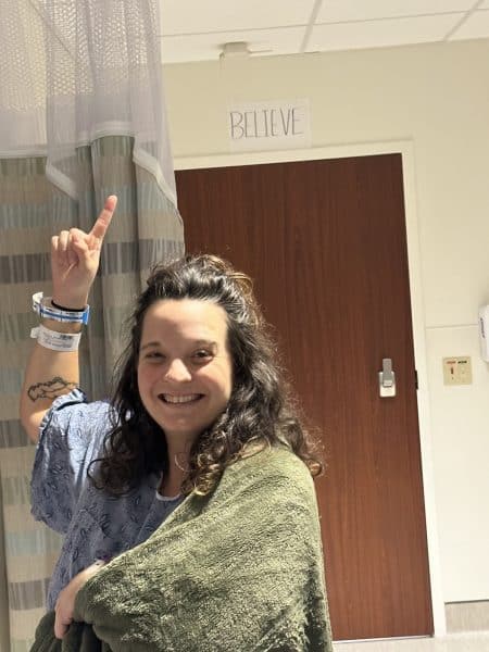 The author is in labor, hooked to wireless monitors, according to her birth plan. She points to a paper sign above her door that says, "BELIEVE," inspired by Ted Lasso.