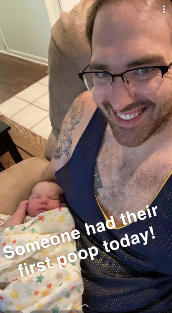 A dad holds a newborn. The text on the picture reads, "someone had their first poop today!"