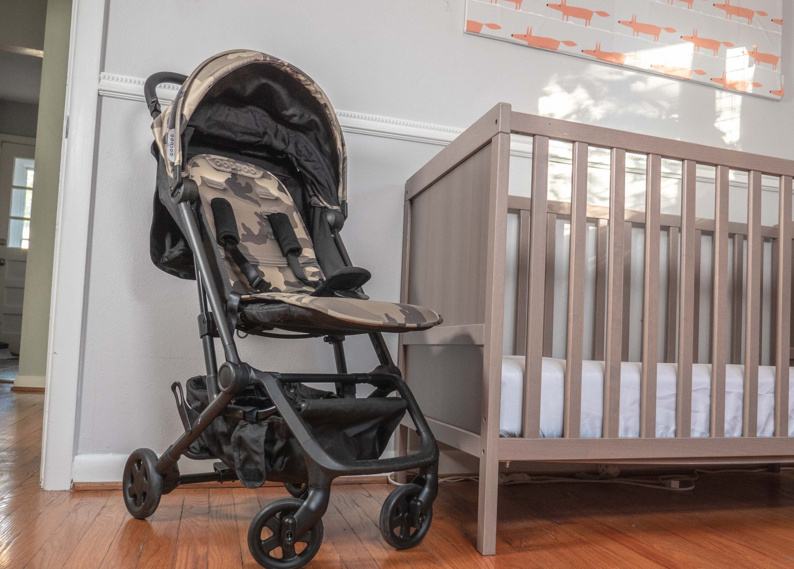 Colugo Compact Stroller next to a crib