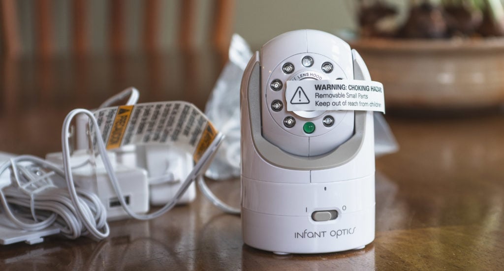 An Infant Optics DXR-8 monitor on at table with a cord