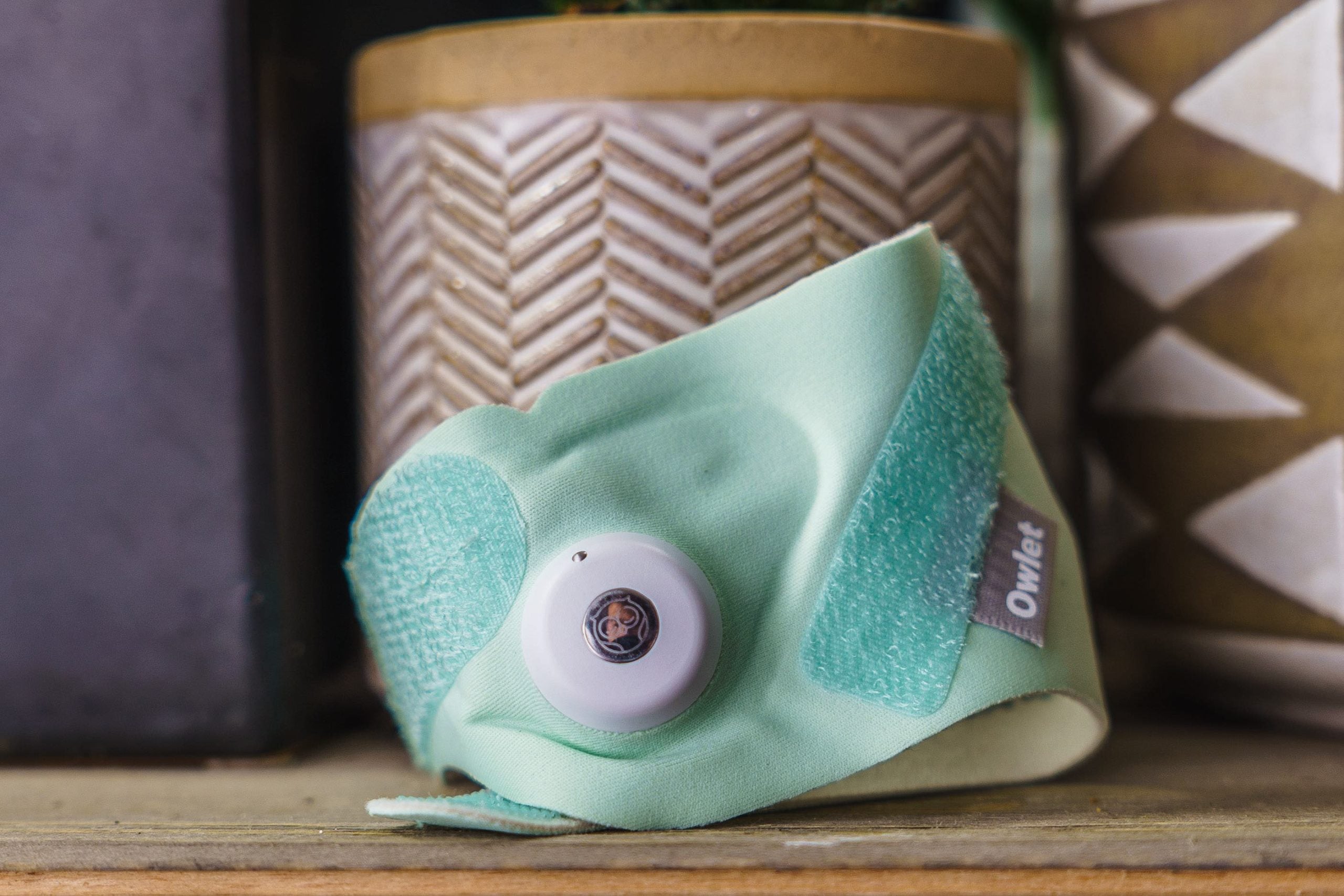 An Owlet 3rd generation Smart Sock on a table