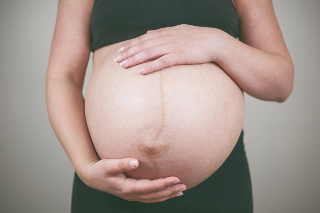 A picture displaying the linea nigra on a pregnant stomach -- A line running from the belly button to the pubic area can be seen.