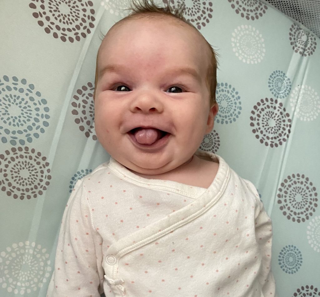 a baby sticks her tongue out at the camera