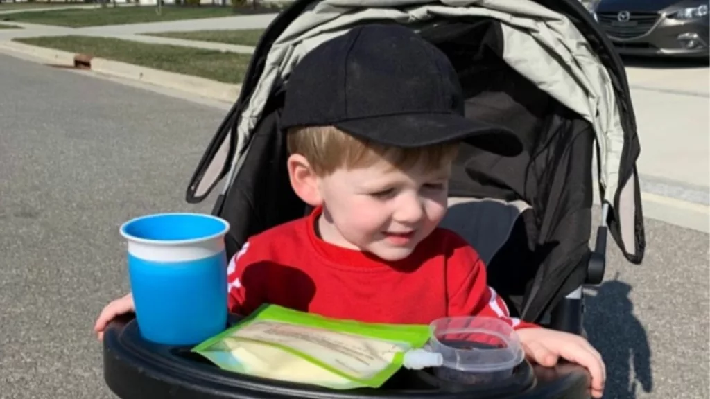 A kid in the Graco FastAction Fold stroller